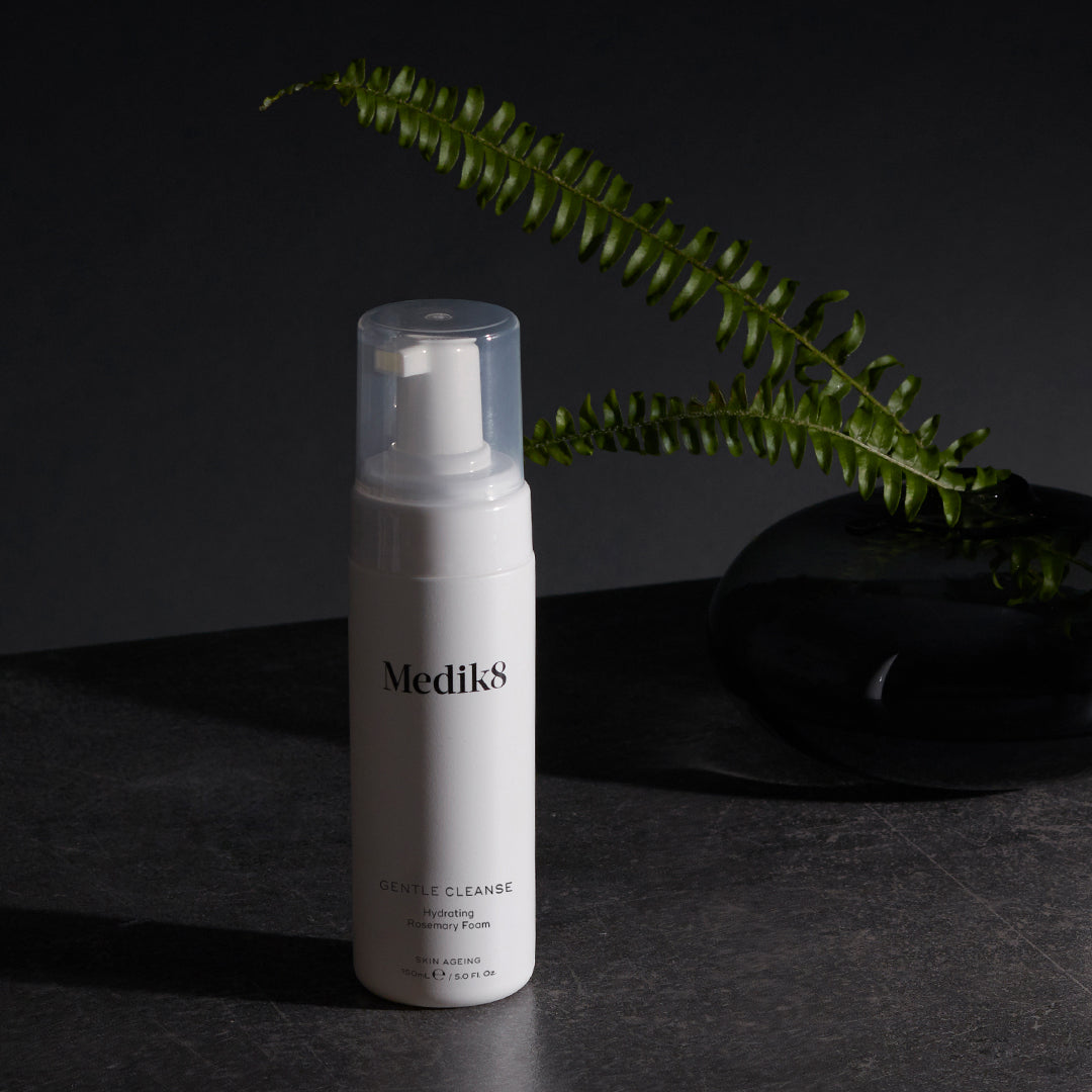 Medik8 Gentle Cleanse flacon sur fond sombre avec fougère