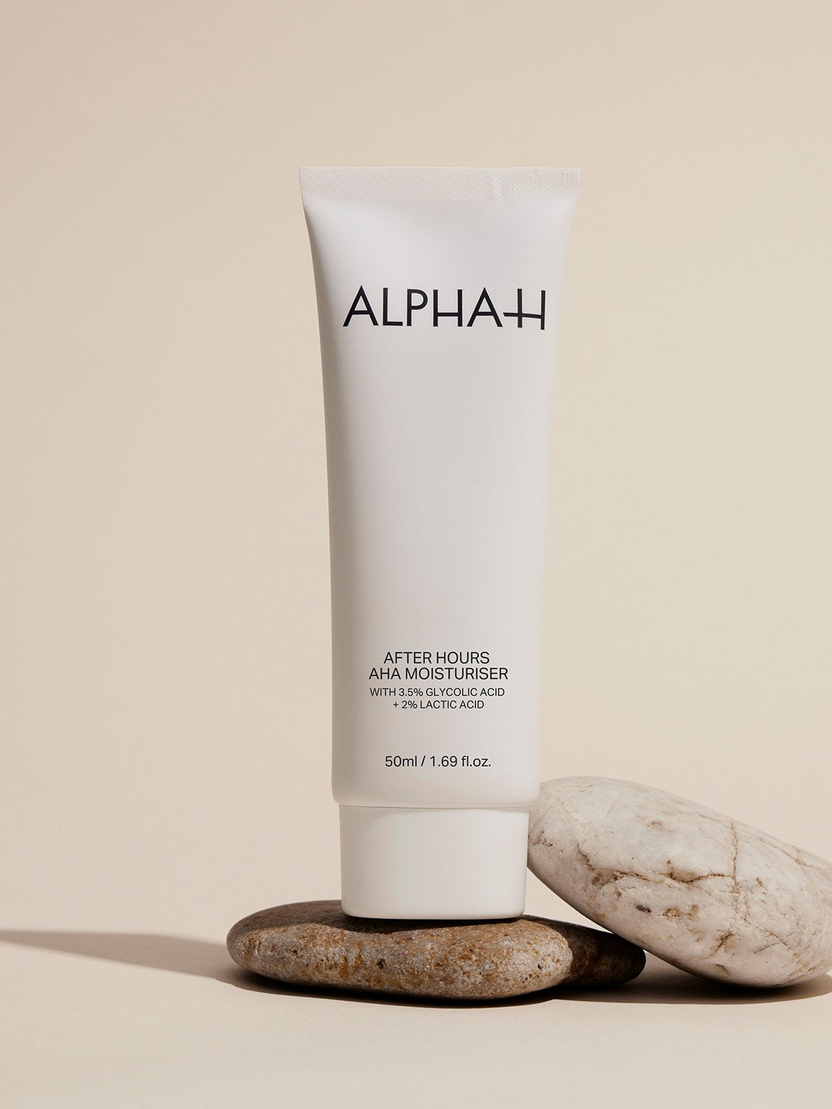 Alpha-H After Hours AHA Moisturiser sur un empilement de pierres