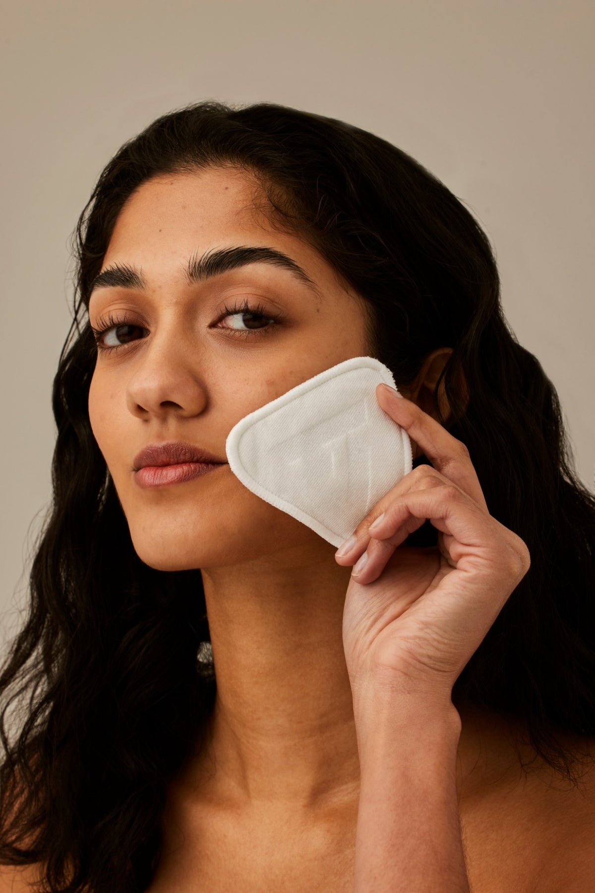 Alpha-H Re-usable Bamboo Cotton Pads modèle avec un disque près du visage