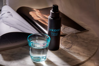 Oolaboo Wipe Off Nectar sur du marbre avec un verre d’eau